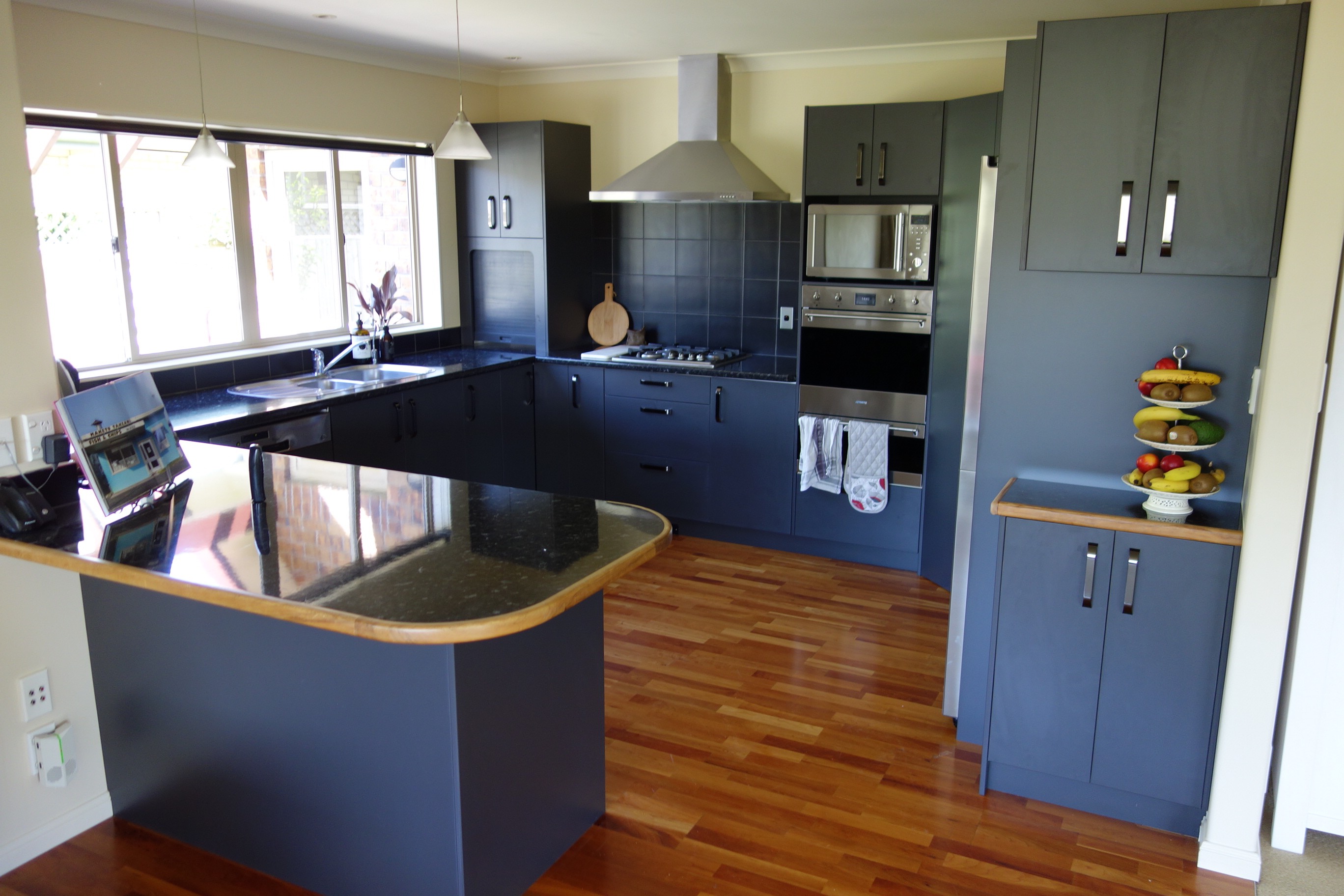 Kitchen after door replacement - modern dark blue doors