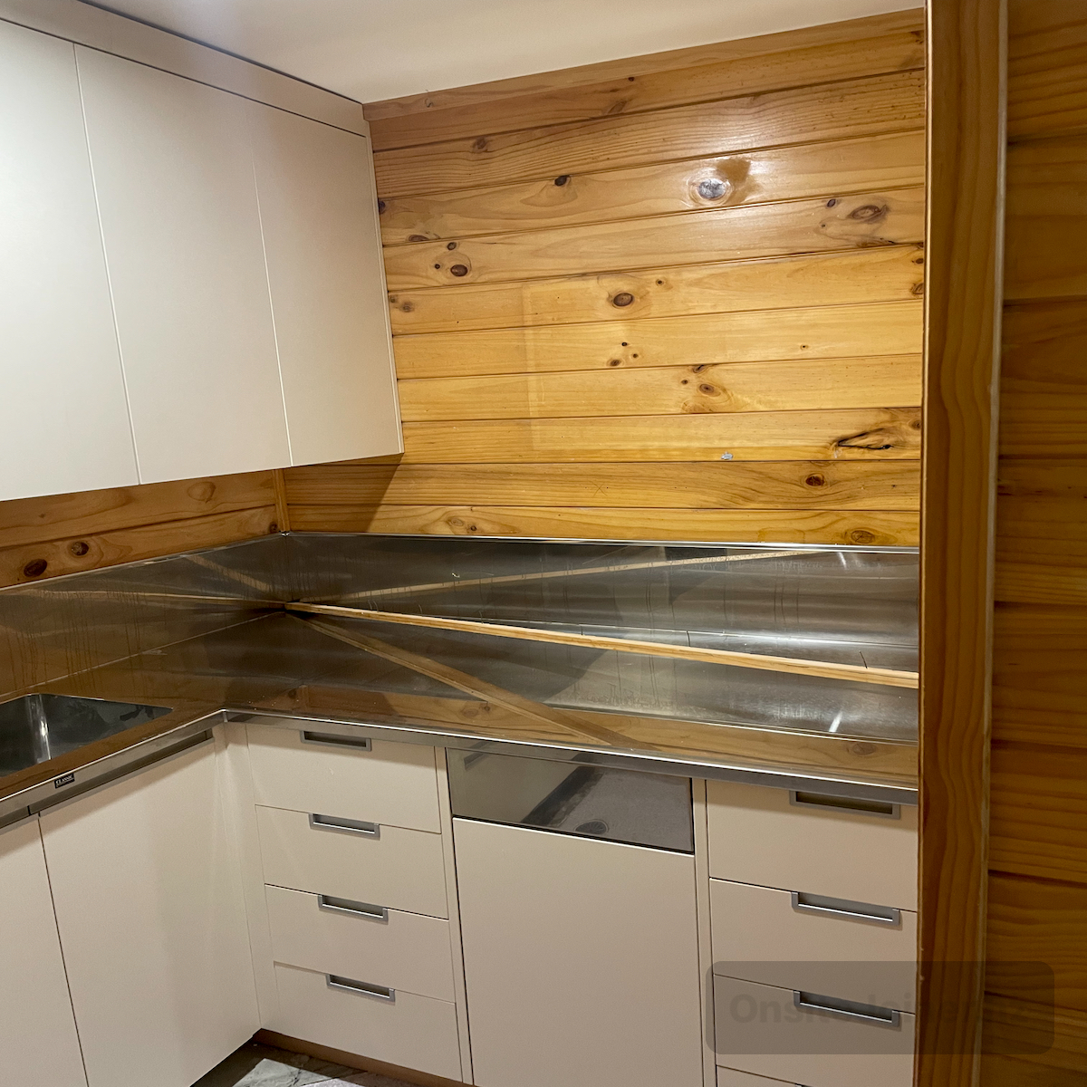 Cream utility kitchen with stainless benchtop and native timber walls